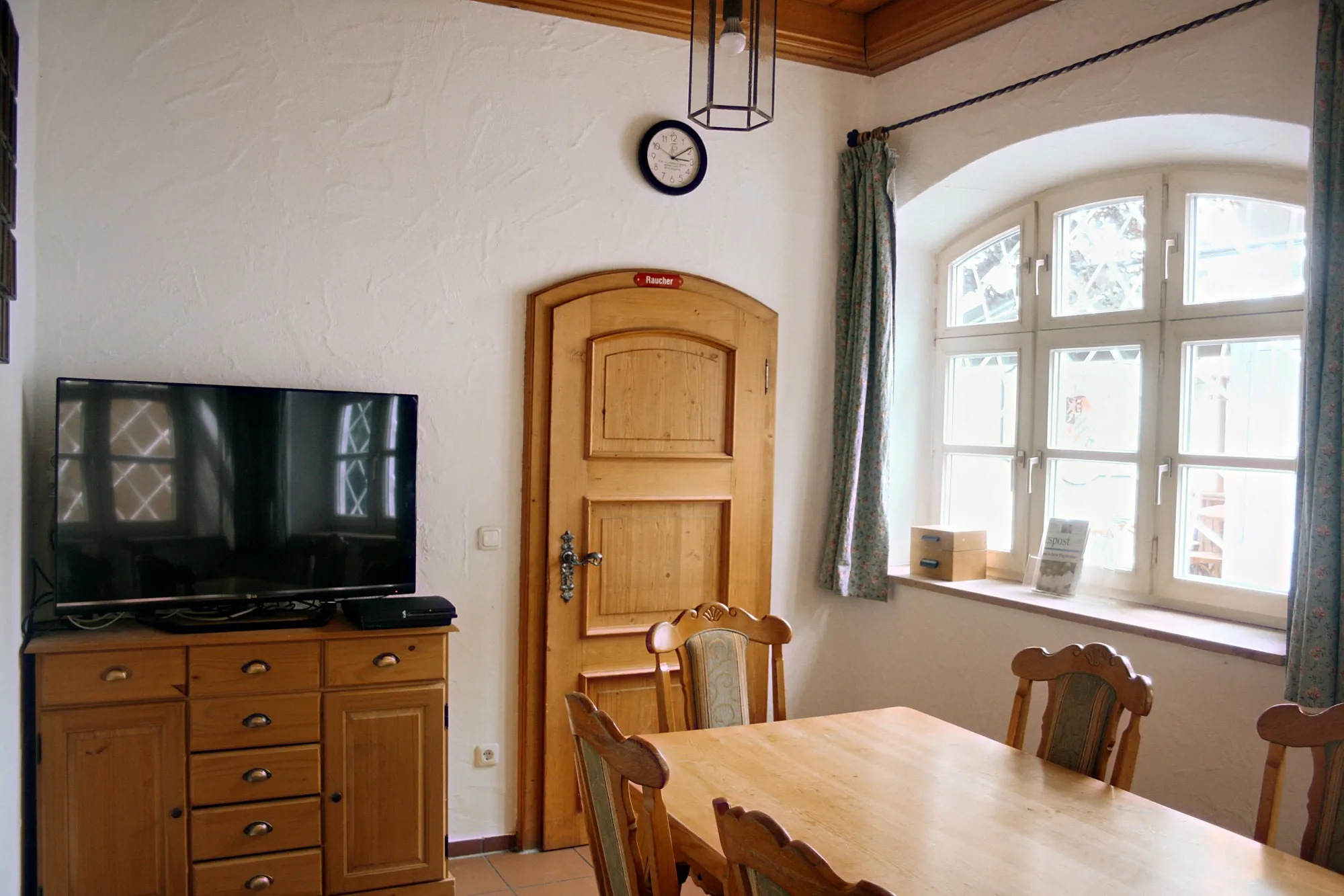 Bierstüble mit Holztisch, Fernseher und Fotowand